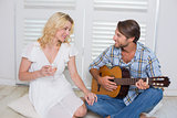Handsome man serenading his girlfriend with guitar