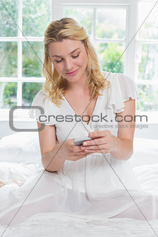 Pretty blonde sitting on bed on the phone
