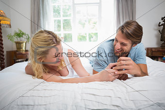 Cute couple relaxing on bed laughing together