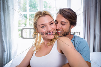 Cute young couple relaxing on bed together