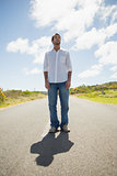 Handsome casual man standing on a road