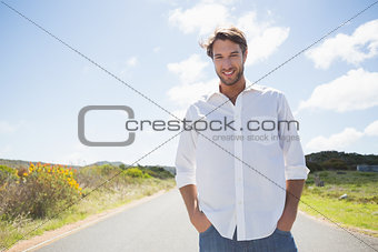 Handsome casual man standing on a road smiling at camera