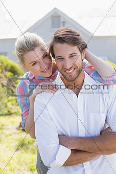 Cute couple smiling at camera together in their garden
