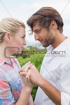 Cute affectionate couple standing outside holding hands