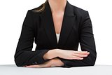 Businesswoman sitting at desk with arms crossed