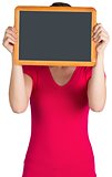 Woman covering face with chalkboard