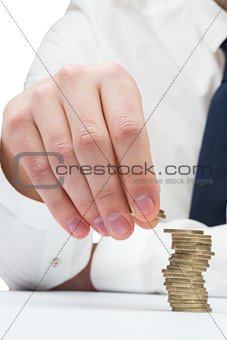 Businessman counting his coins at desk