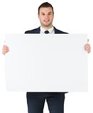 Smiling businessman showing large card