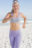 Sporty blonde jogging on the beach