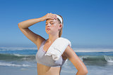 Sporty blonde standing on the beach with towel