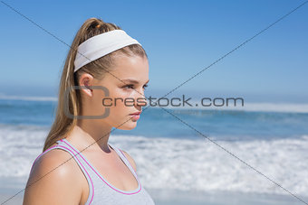 Sporty serious blonde standing on the beach