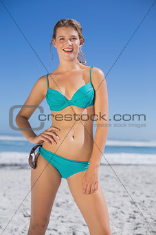 Fit woman in bikini on beach smiling