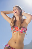 Laughing blonde in floral bikini on the beach