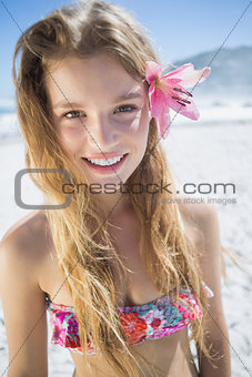 Beautiful smiling blonde with flower hair accessory on the beach