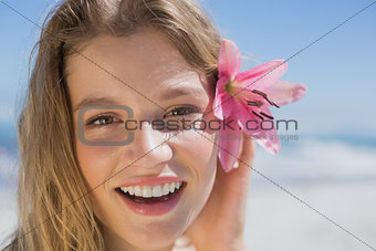 Beautiful happy blonde with flower hair accessory on the beach