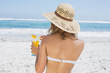 Woman holding cocktail on the beach