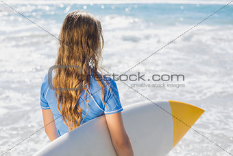 Fit surfer girl on the beach with her surfboard