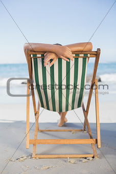 Woman relaxing in deck chair on the beach