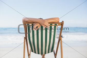 Woman relaxing in deck chair on the beach