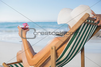 Woman relaxing in deck chair with cocktail