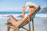 Pretty woman relaxing in deck chair on the beach