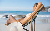 Pretty woman relaxing in deck chair on the beach