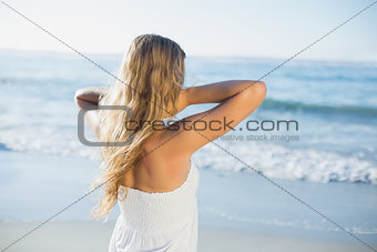 Beautiful blonde in white sundress on the beach