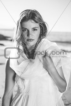 Beautiful blonde in white sundress and scarf on the beach