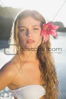 Beautiful blonde with flower hair accessory on the beach