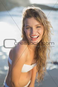 Beautiful smiling blonde in white bikini at the beach