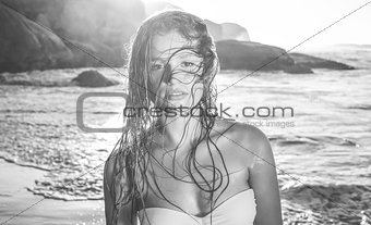 Beautiful blonde in white bikini at the beach with wet hair
