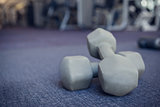 Grey dumbbells on the weights room floor