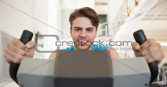 Smiling fit man on the exercise bike