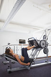 Fit woman using weights machine for legs