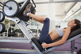 Fit woman using weights machine for legs
