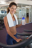 Fit woman wearing towel around shoulders on the treadmill