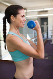 Smiling woman lifting blue dumbbell
