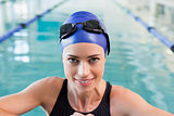 Fit swimmer in the pool smiling at camera