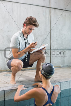 Swimmer talking to her coach poolside