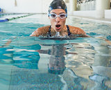 Fit swimmer coming up for air in the swimming pool