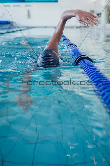 Fit swimmer doing the front stroke in the swimming pool