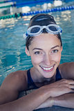 Fit swimmer smiling at camera in the swimming pool