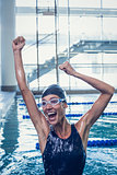 Excited swimmer jumping up the swimming pool