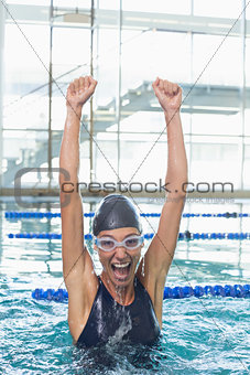 Excited swimmer jumping up the swimming pool