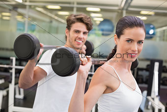 Fit couple lifting barbells together