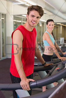 Smilng man and woman on the treadmills