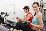Smiling brunette working out on the rowing machine