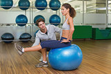 Trainer watching his client using exercise ball