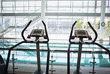Cross trainer machines overlooking large swimming pool