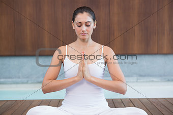Peaceful woman in white sitting in lotus pose